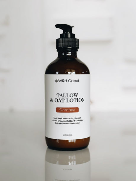 An amber glass pump bottle of Wild Capri Tallow & Oat Lotion, featuring a white label with black text and a small orange accent, set against a bright, softly blurred white background.