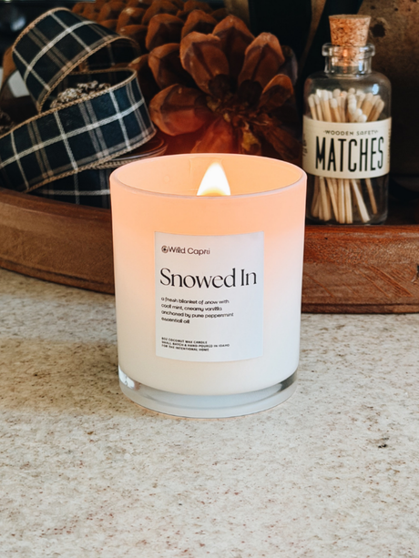 a winter candle called Snowed by Wild Capri lit on the kitchen counter